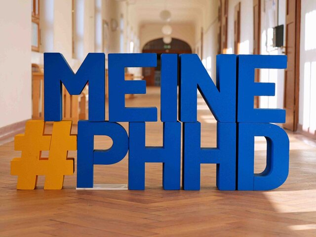 Buchstaben #Meine PHHD in blau, im Flur des Altbaus der Pädagogischen Hochschule Heideberg.