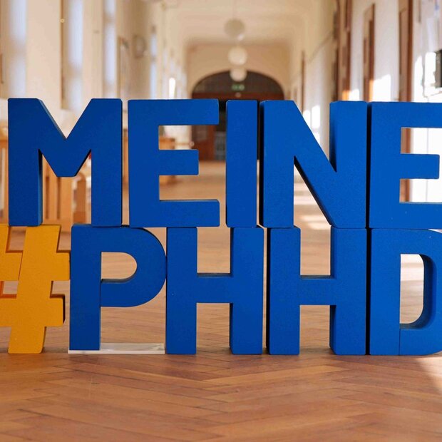 Buchstaben #Meine PHHD in blau, im Flur des Altbaus der Pädagogischen Hochschule Heideberg.
