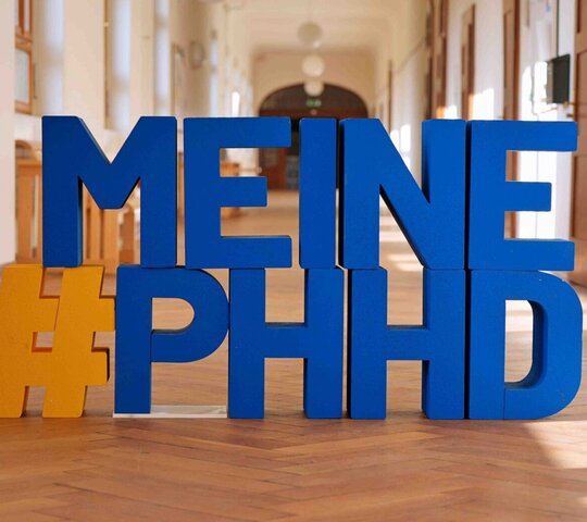 Buchstaben #Meine PHHD in blau, im Flur des Altbaus der Pädagogischen Hochschule Heideberg.