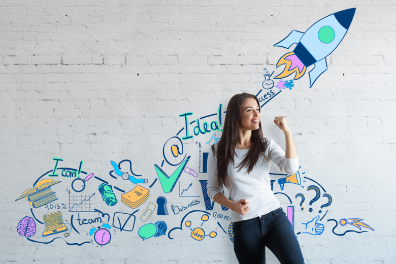 Eine Frau, die vor einer bunten Wand mit positiven Affirmationen, wie bspw. "I can", steht und ihre Faust in einer Gewinnerpose geballt hat. Dies soll verdeutlichen, dass PHeelGood mit den Mentalstrategien zur mentalen Gesundheit beitragen möchte. 
