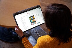 Das Bild ist über die Schulter einer Frau fotogragiert. Sie hält ein Tablet, auf dem man die Buchreihe "Wirksamer Fachunterricht" sieht. Copyright: PH Heidelberg