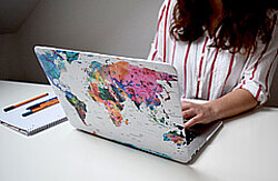  Laptop, auf dessen Rückseite mit einer Weltkarte beklebt ist