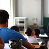 Das Foto zeigt sitzende Studierende in einem Hörsaal.