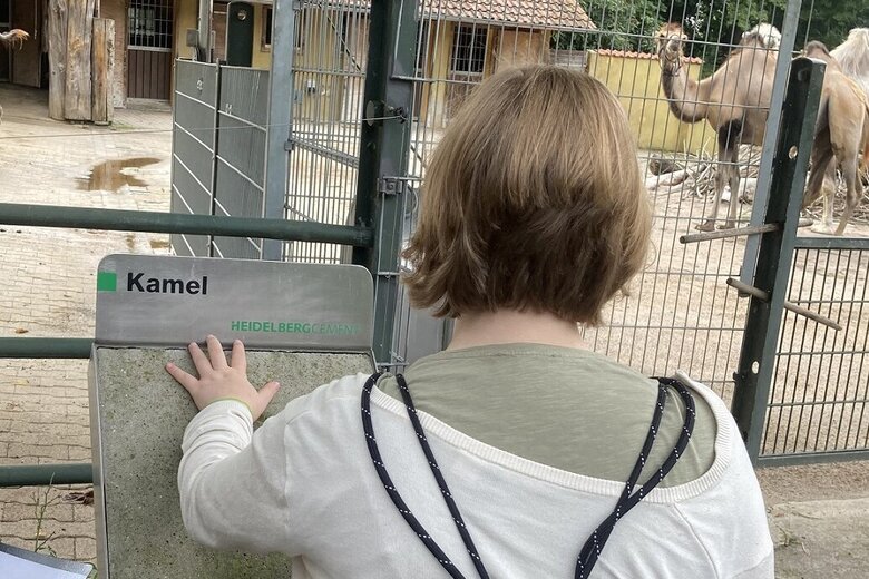 Zu sehen ist eine Studentin an einer Lesetafel im Zoo.