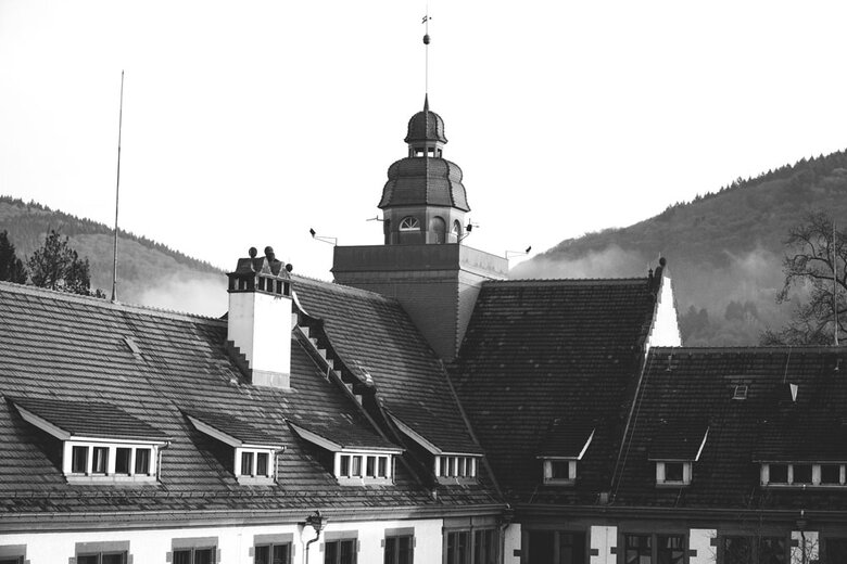 Das Schwarz-Weiß-Bild zeigt den Altbauturm der Hochschule. Im Hintergrund sieht man die Bergstraße.