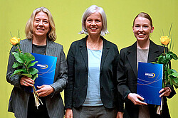 Veronika Cook-Jeltsch, Frauke Janz und Jana Steinbacher nach der Verleihung. Die Preisträgerinnen halten ihre Urkundenmappe und eine gelbe Rose in der Hand. Alle lachen freundlich in die Kamera.