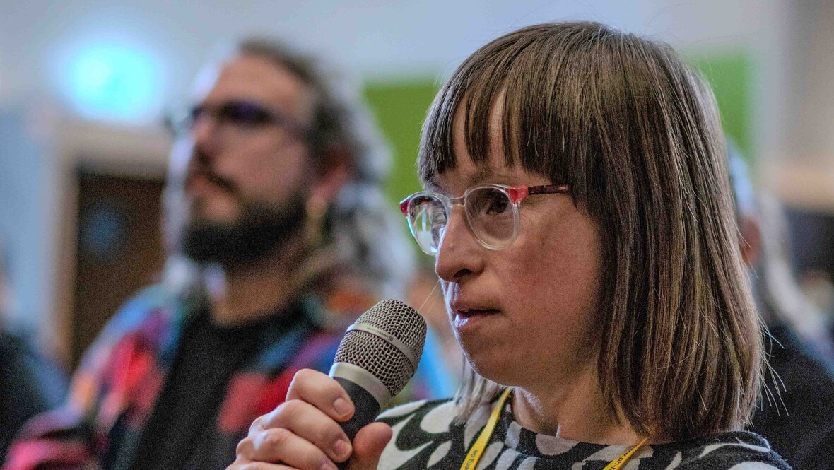 Qualifizierungsteilnehmerin Susann Bensch stellt im Rahmen der Podiumsdiskussion eine Frage aus dem Publikum.