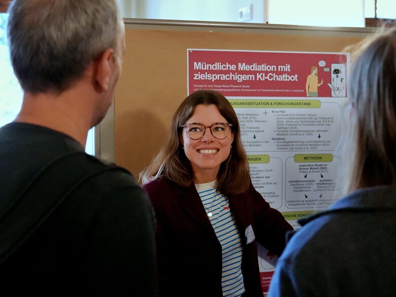 Eine junge Wissenschaftlerinnen präsentiert während der DGFF-Tagung ihre Forschung zu KI-Chatbots. Das Bild wurde in der Aula der PHHD aufgenommen. 