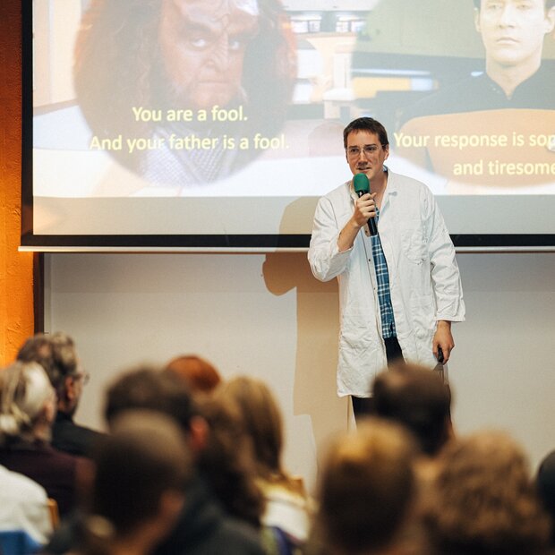 Zu sehen ist ein Wissenschaftler bei einem Science Slam.