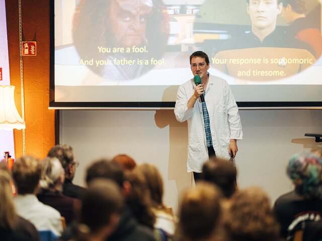 Zu sehen ist ein Wissenschaftler bei einem Science Slam.