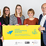 Foto: Deutsche UNESCO-Kommission / Thomas Müller Vier Personen mit einem gelben Plakat.