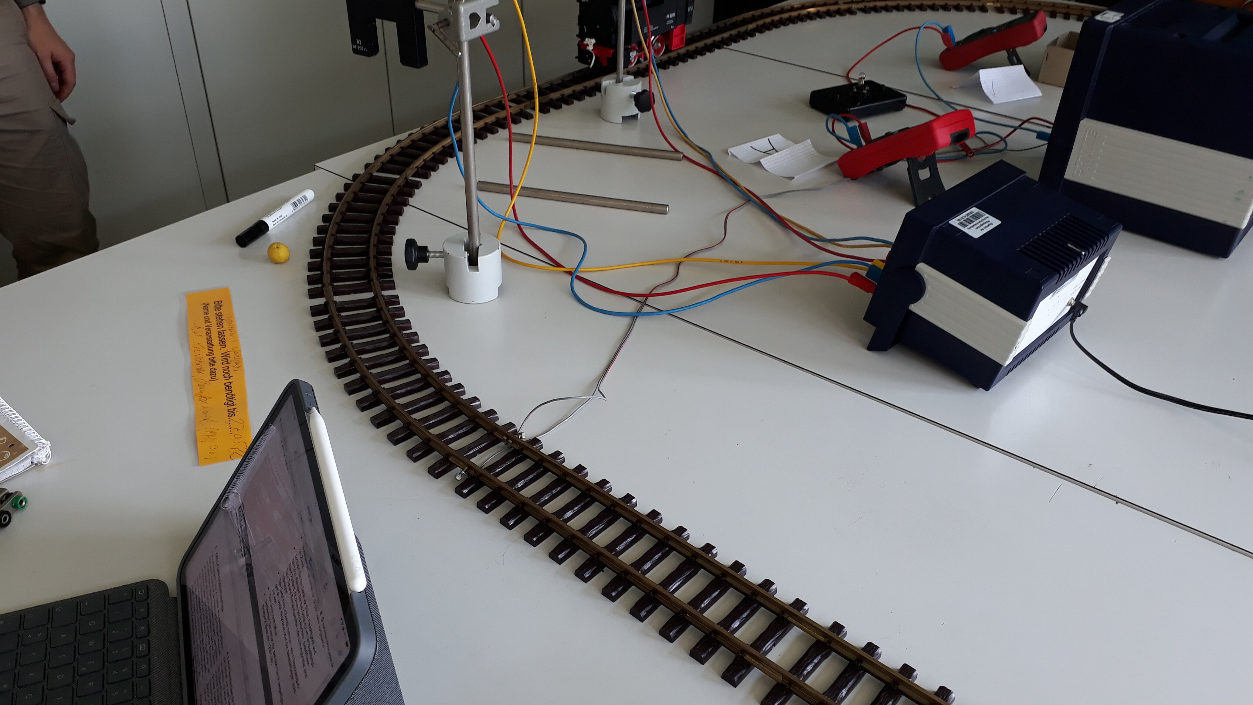 Zu sehen ist die Schiene einer Spielzeugeisenbahn auf einem Tisch.
