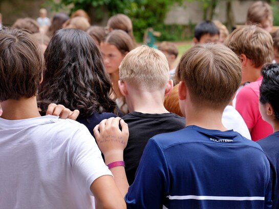 Zu sehen sind Schüler:innen von hinten auf dem Pausenhof