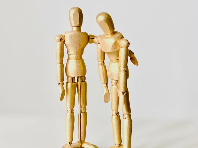 Figur tröstet andere Figur