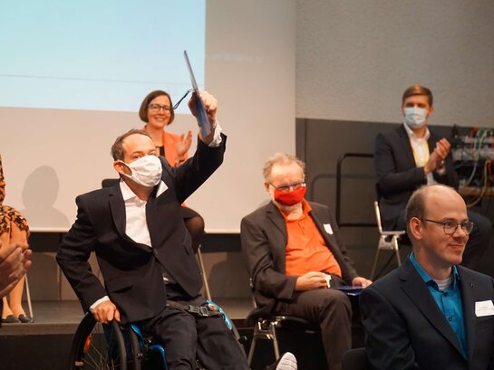 Das Bild zeigt verschiedene Personen mit Abstand sitzend bei der Eröffnung des AW-ZIBs.