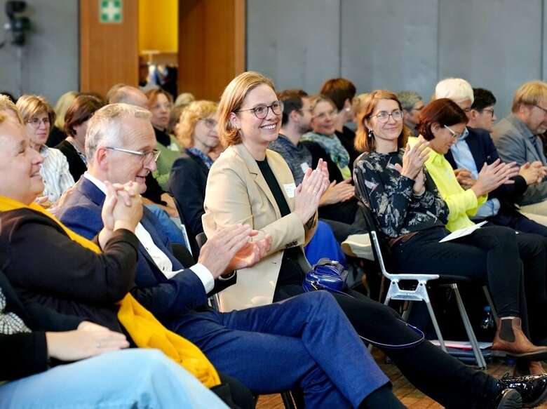 Blick ins Publikum der QuaMath-Jahrestagung. Der Schwerpunkt des Fotos liegt auf Marita Friesen.