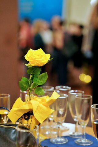 Zu sehen ist eine gelbe Rose und leere Sektgläser.