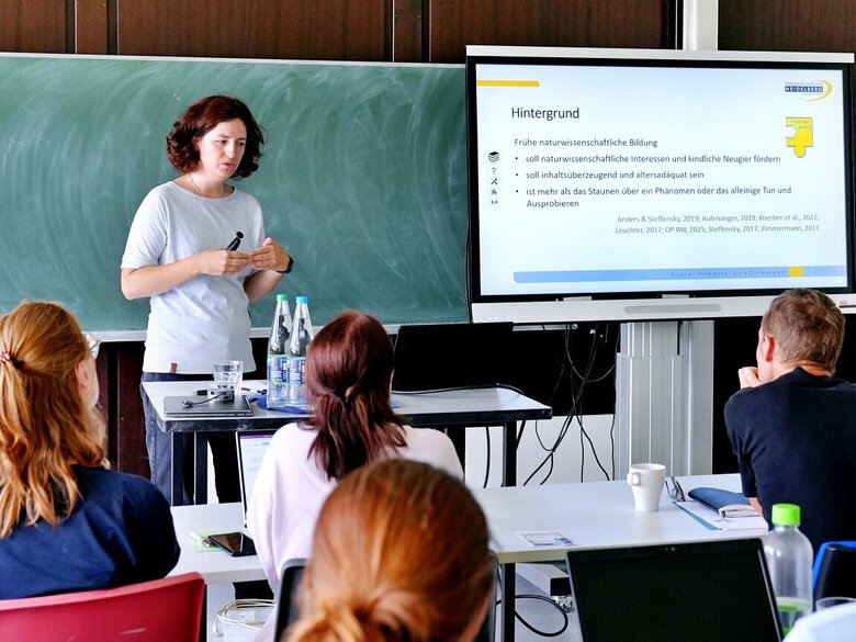 Eine Promovierende erklärt in einer Präsentation ihre Doktorarbeit beim Nachwuchskolloquium 2026.