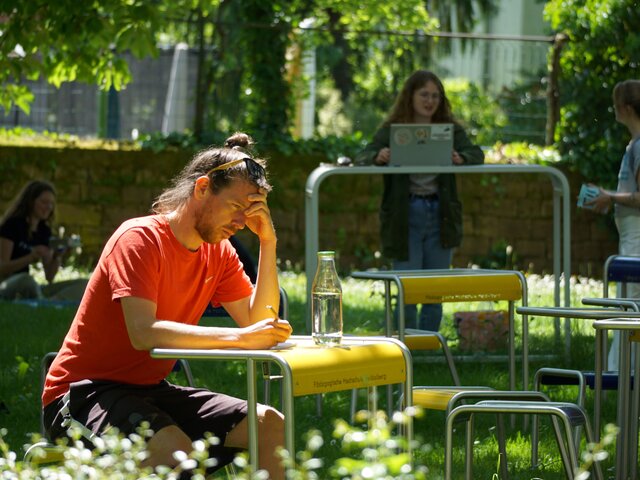 Ein Student der PH Heidelberg sitzt im Außenseminarbereich der Alten PH, im sogenannten "Keplerhof"