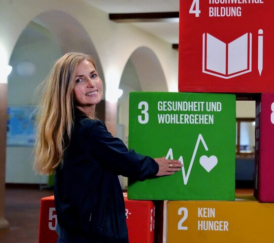 Zu sehen ist Christiane Bauer mit den SDG-Würfeln.