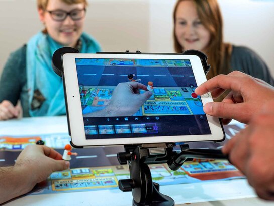 Nutzung (digitaler) Technologien Zwei Studentinnen im Hintergrund, im Vodergrund wird ein iPad bedient.