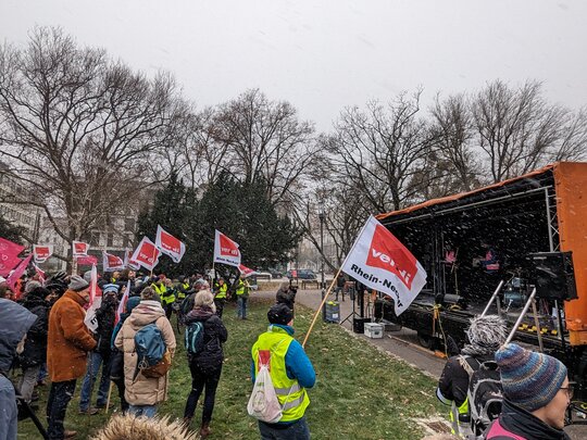 Zu sehen ist eine Demonstration mit Kundgebung und verdi-Fahnen.