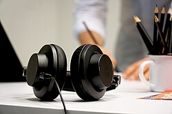 schwarze Kopfhörer auf einem Schreibtisch.