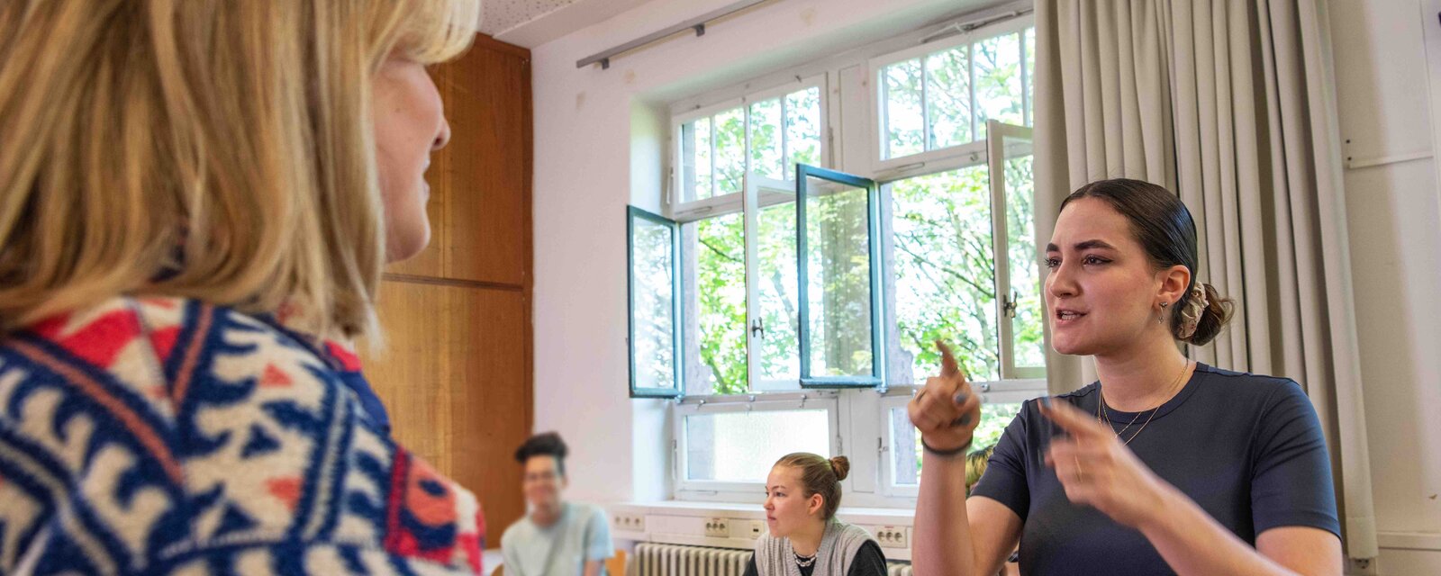 Studierende des Bachelor Gebärdensprachdolmetschen verständigen sich im Seminar und lernen eine Brücke zwischen Gehörlosen und Hörenden zu bauen.