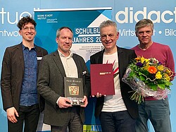 Vier Männer mit dem Buch "MusikKunst - Kultur verstehen im Wechselspiel der Künste" von Dr. Mathias Schillmöller (Institut für Kunst, Musik und Medien) wurde mit dem Preis "Schulbuch des Jahres 2018" in Silber ausgezeichnet wurde.