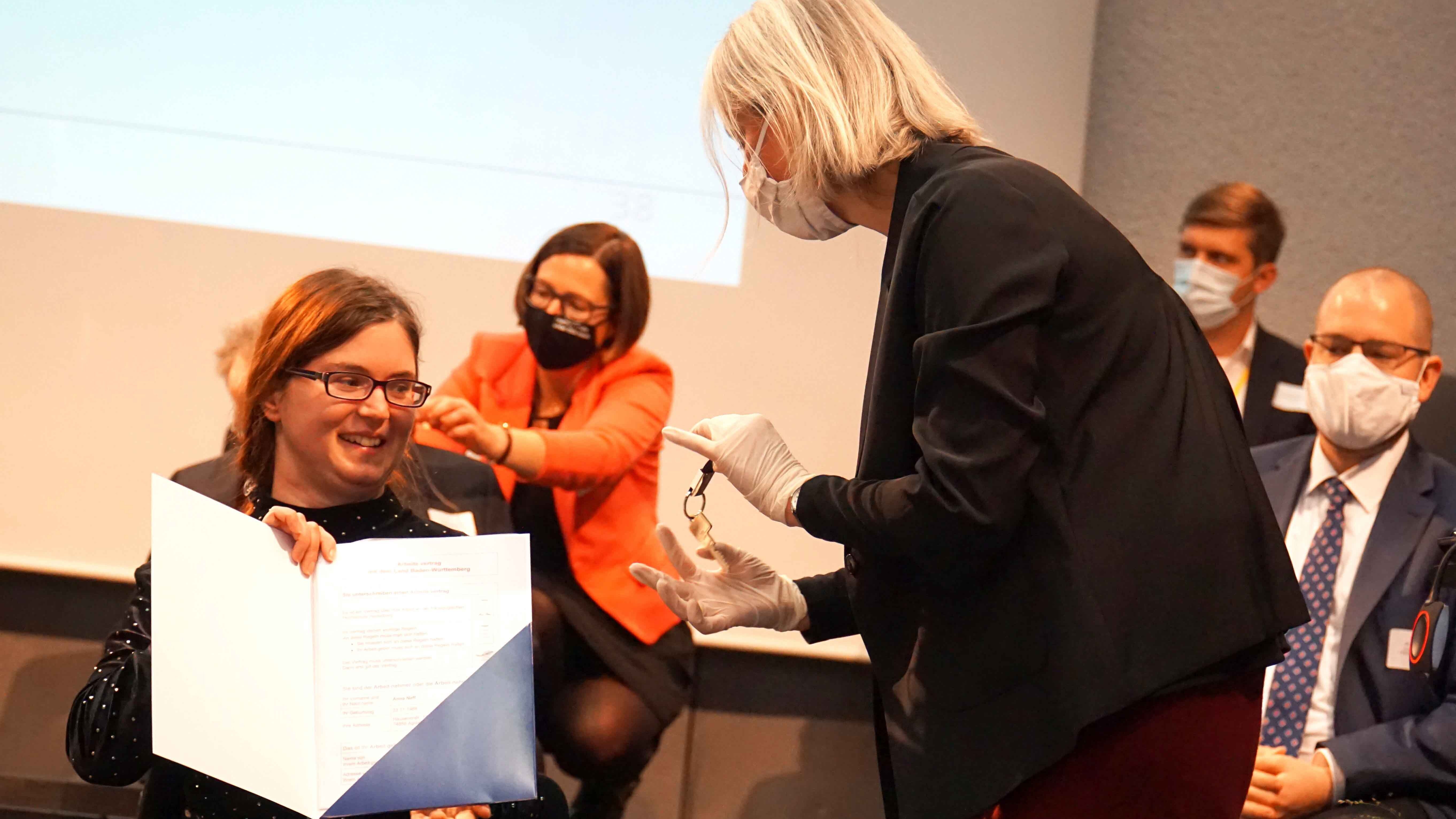 Übergabe des Arbeitsvertrages und des Büroschlüssels an Anna Neff durh Prof. Vera Heyl.