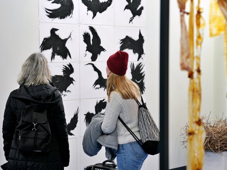 Zu sehen sind 2 Personen von hinten beim Betrachten eines Kunstwerks