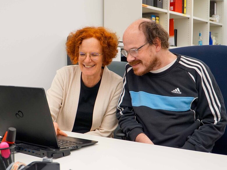 Ute Raible und Thilo Krahnke sitzen am Schriebtisch vor einem Laptop. 