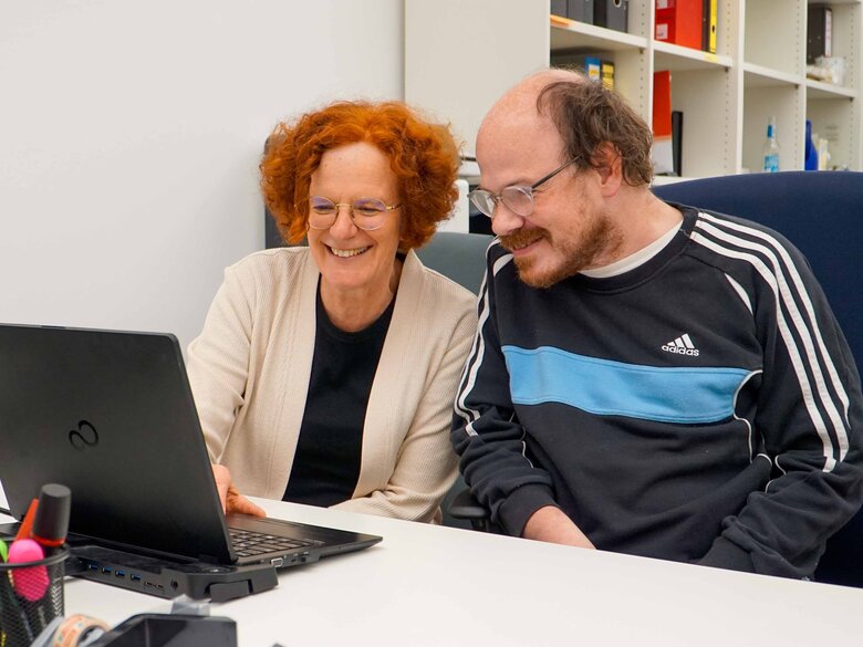 Ute Raible und Thilo Krahnke sitzen am Schriebtisch vor einem Laptop. 