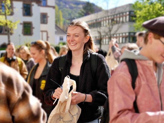 Studentin steht in einer Menschenmenge.