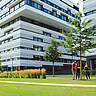 Auf dem Bild sieht man im Hintergrund groß die futuristischen Skylabs der Heidelberger Bahnstadt. Im Vordergrund sieht man Gründfläche und rechts eine kleine Gruppe von Studierenden. Copyright: PH Heidelberg