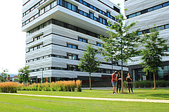 Auf dem Bild sieht man im Hintergrund groß die futuristischen Skylabs der Heidelberger Bahnstadt. Im Vordergrund sieht man Gründfläche und rechts eine kleine Gruppe von Studierenden. Copyright: PH Heidelberg