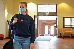 Auf dem Bild sieht man eine Studierende mit Maske im Foyer der Ph.