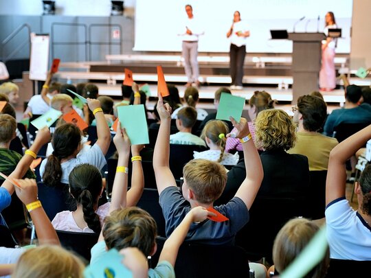 Die Grundschüler:innen stimmen im Rahmen des Kinderparlamentes vom grünen und roten Karten ab. Aufgenommen wurde das Foto in der Festehalle der Pädagogischen Hochschule Heidelberg.