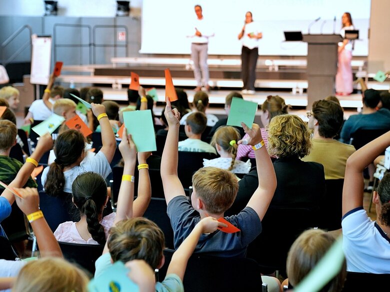 Die Grundschüler:innen stimmen im Rahmen des Kinderparlamentes vom grünen und roten Karten ab. Aufgenommen wurde das Foto in der Festehalle der Pädagogischen Hochschule Heidelberg
