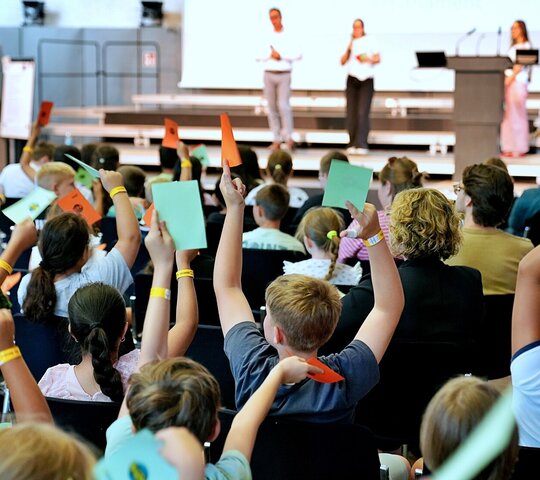 Die Grundschüler:innen stimmen im Rahmen des Kinderparlamentes vom grünen und roten Karten ab. Aufgenommen wurde das Foto in der Festehalle der Pädagogischen Hochschule Heidelberg