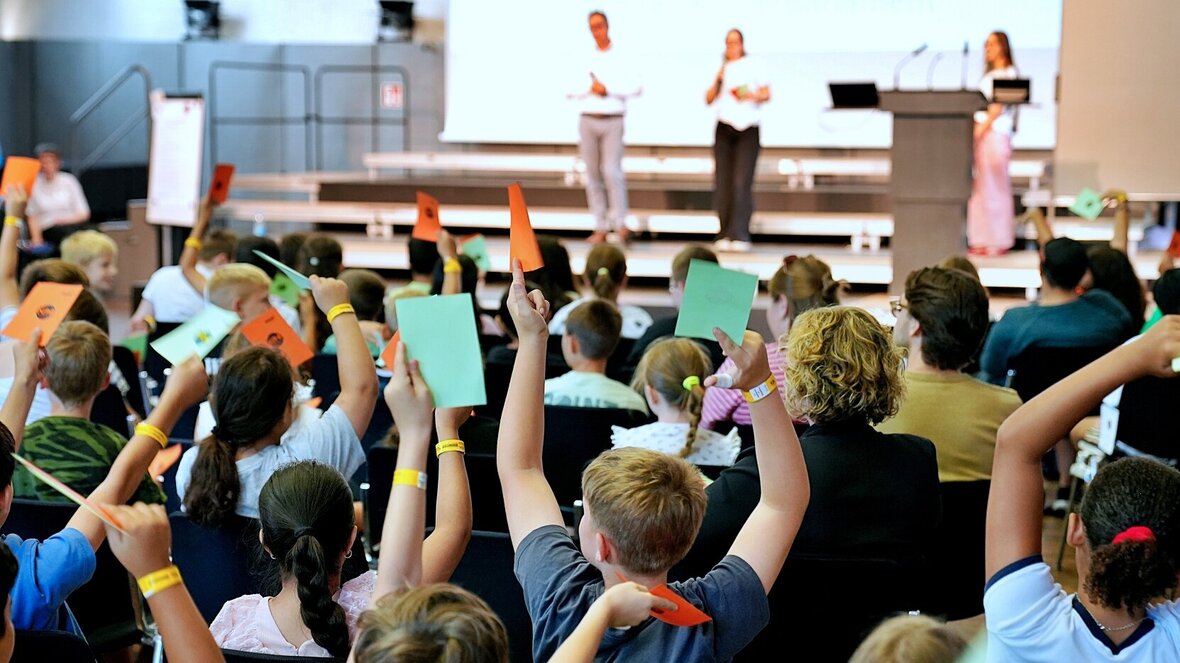 Die Grundschüler:innen stimmen im Rahmen des Kinderparlamentes vom grünen und roten Karten ab. Aufgenommen wurde das Foto in der Festehalle der Pädagogischen Hochschule Heidelberg.