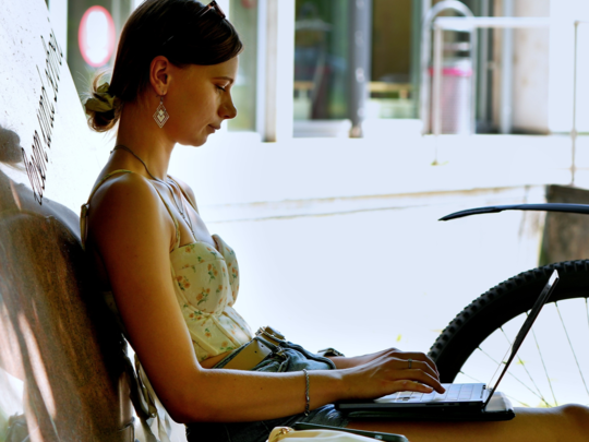 Zwei jungen Frauen sitzen vor einem Laptop.