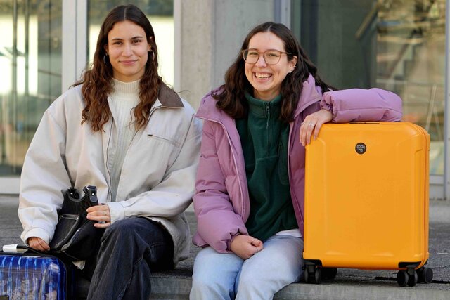 Zu sehen sind zwei Studentinnen der Pädagogischen Hochschule Heidelberg mit zwei Koffern. 