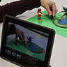 Das Foto zeigt ein Tablet dass Playmobil Figuren fotografiert.