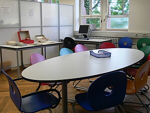 ovaler Tisch mit 11 Stühlen sowie Computerarbeitsplatz