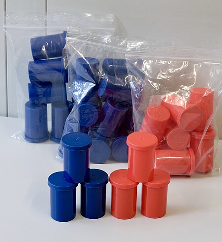 Die kleinen runde Plastikdosen mit Deckel sind rot und blau. Eine genauere Beschreibung liefert der Text unterhalb des Bildes.