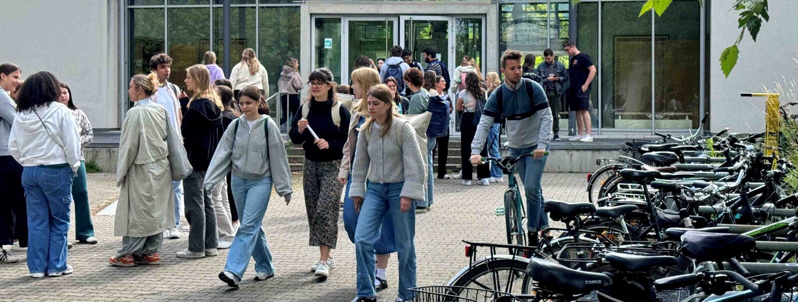 Auf dem Bild sind mehrere Personen vor dem Hörsaalgebäude der Neuen PH zu sehen.