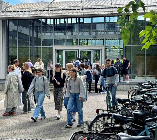 Auf dem Bild sind mehrere Personen vor dem Hörsaalgebäude der Neuen PH zu sehen.
