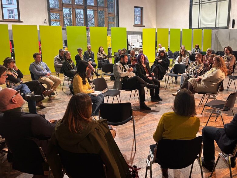 Zu sehen sind Teilnehmer:innen der Abschlussveranstaltung der Arbeitsstelle Antiziganismusprävention in einer Fishbowl.