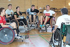 Auf dem Symbolbild sieht man eine Gruppe von Rollstuhlfahrern. Sie sitzen im Kreis. Das Bild wurde in der Turnhalle der Hochschule aufgenommen. 